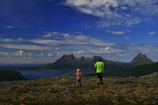 蓝天白云在大海旁高山山顶的父子