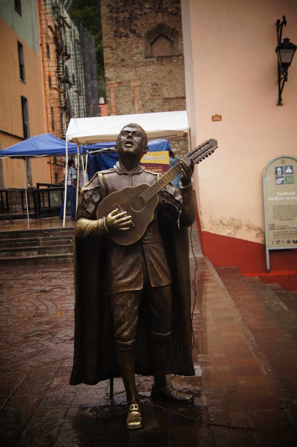 雨后街头上正弹琴歌唱的铜雕像