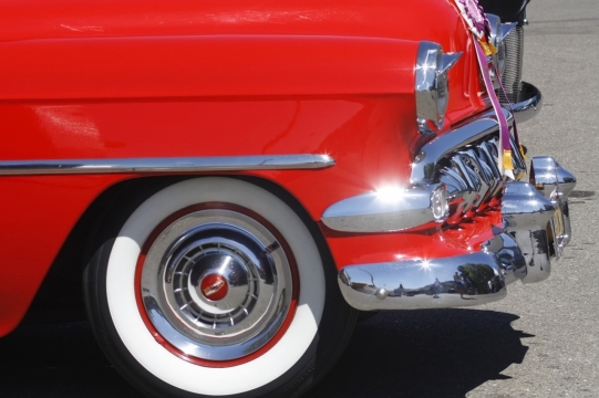 城市街道马路上红色轿车车轮特写