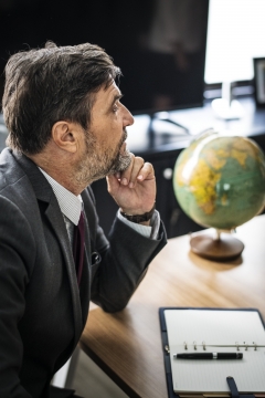 办公室室内木制桌子前思考商务男性