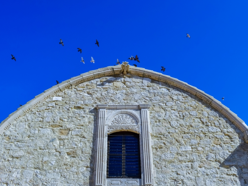 塞浦路斯教堂上天空飞过鸽子