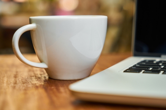 室内木制桌面白色咖啡杯笔记本电脑