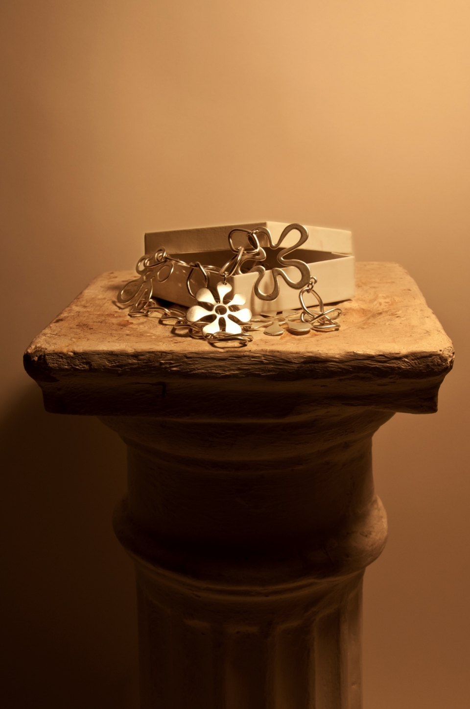 圆柱石板上木盒子里的金属花朵钥匙圈