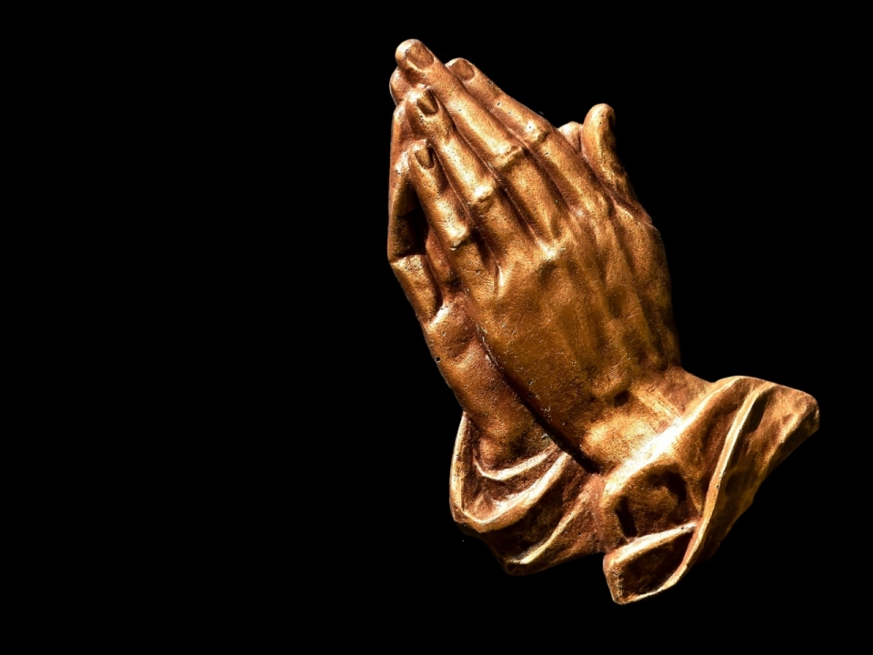 合掌祈祷的铜制雕塑
