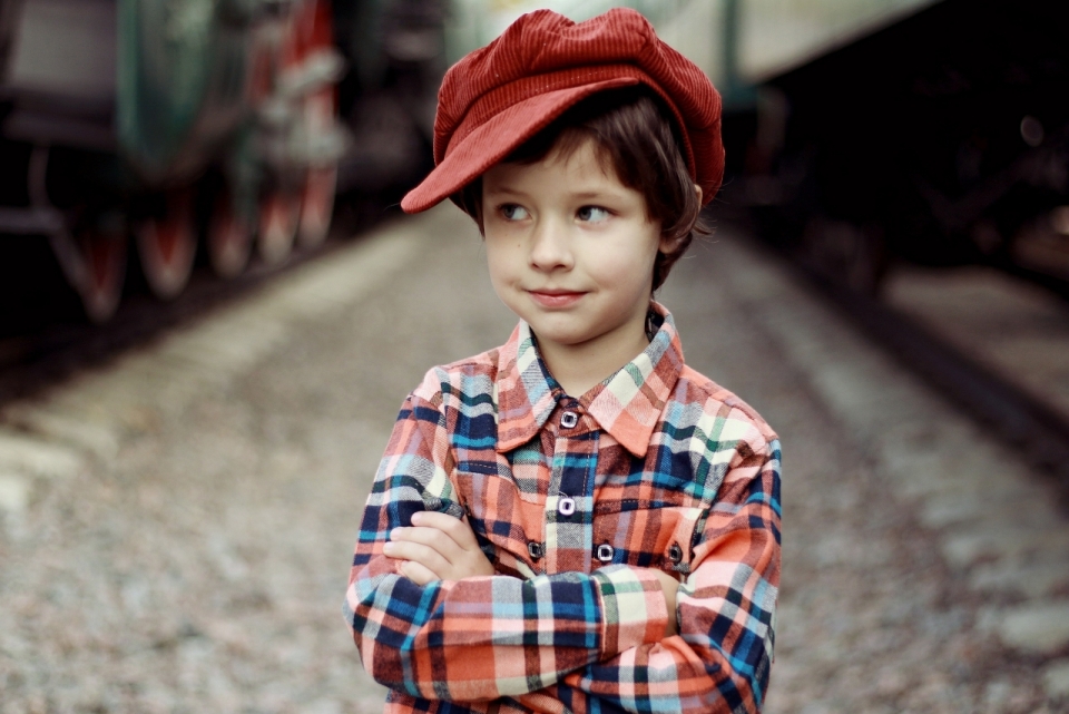 戴红帽子小男孩站在火车边人像写真