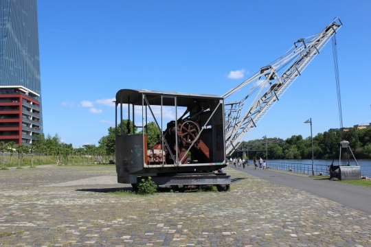 蓝天白云下河边搬运货物的吊车