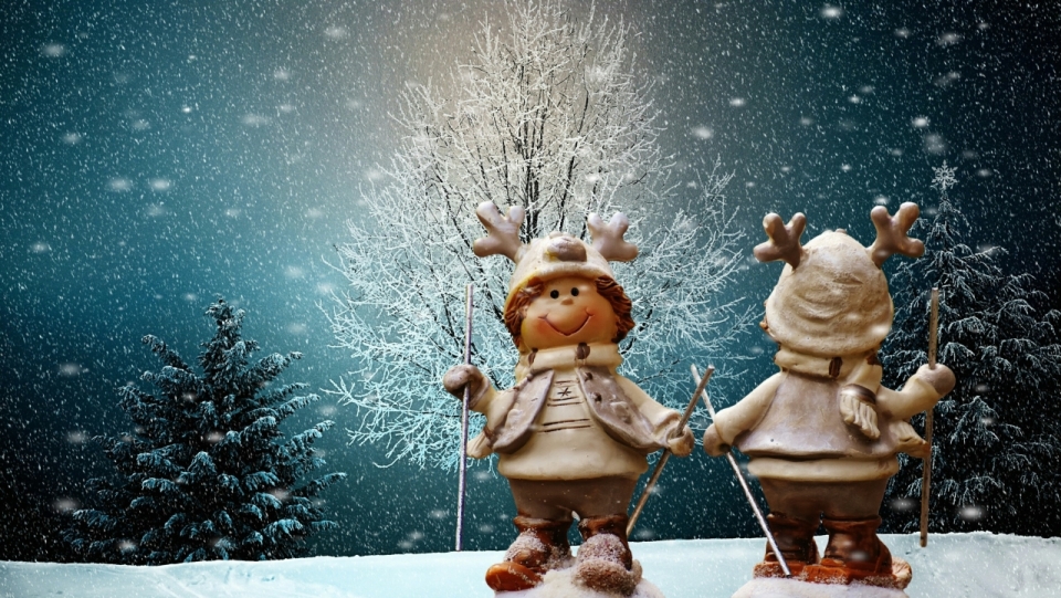 冬天雪地树木前戴鹿角帽子的玩偶