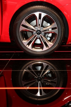 反光地面红色轿车车轮特写