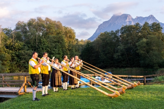 美丽乡间小河旁练习吹奏名族乐器的人们