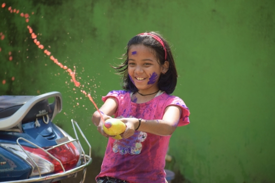 浑身沾满颜料玩耍的小女孩