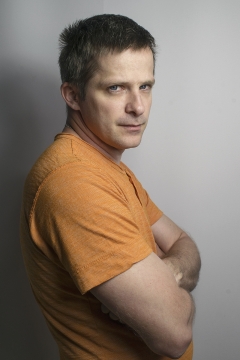 昏暗室内抱胸短发穿黄色T恤男性