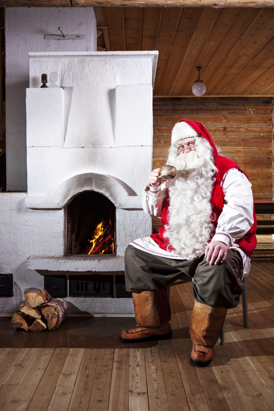 小木屋火炉旁喝水的圣诞老人