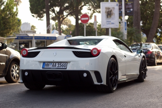 街道边缓慢行驶白色超跑轿车外观