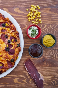 木桌上美味诱人披萨和制作食材