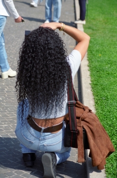 阳光城市街道半跪长发女性背影