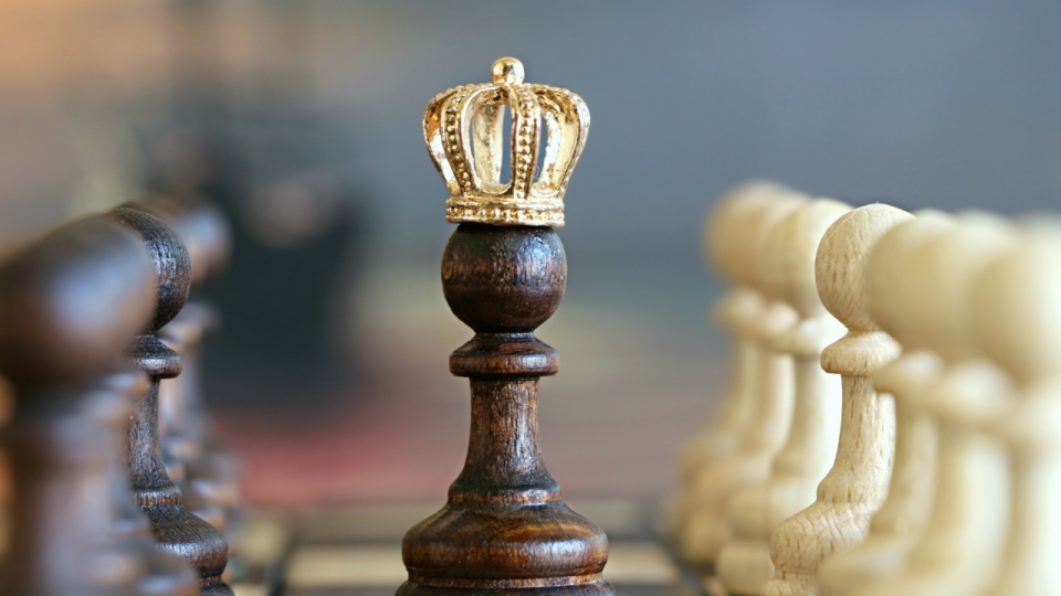 虚化背景国际象棋棋盘带金色王冠黑色棋子