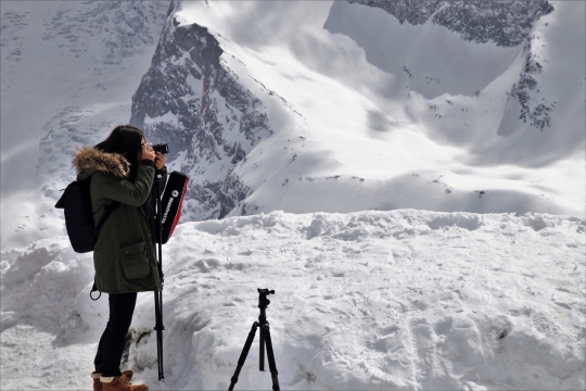 雪山坡道矗立三脚架女性摄影师外景