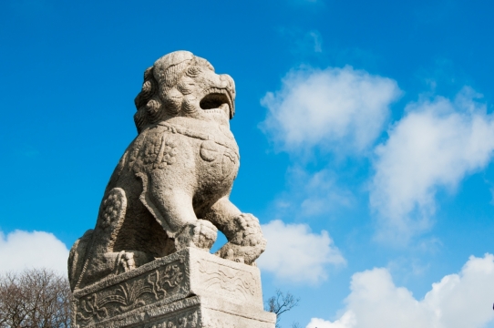 晴朗蓝色天空下白色狮子古老雕塑