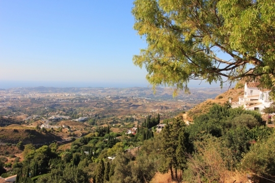 晴朗天空山坡俯瞰平原风光