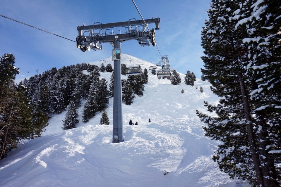 雪山山坡间的缆车索道中转塔特写