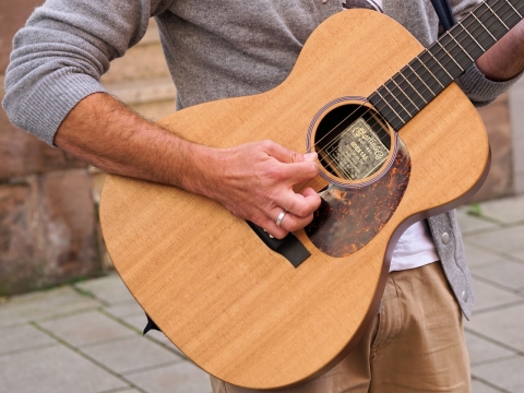 街边正在弹吉他的人半生和吉他特写摄影