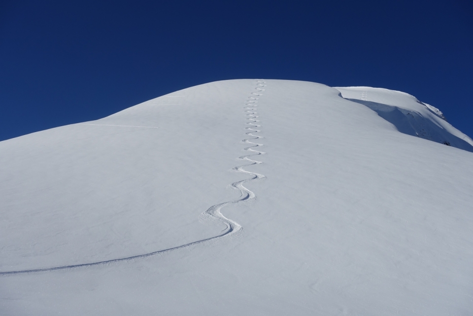 风景摄影_洁白雪山上蜿蜒曲折爬行痕迹外景