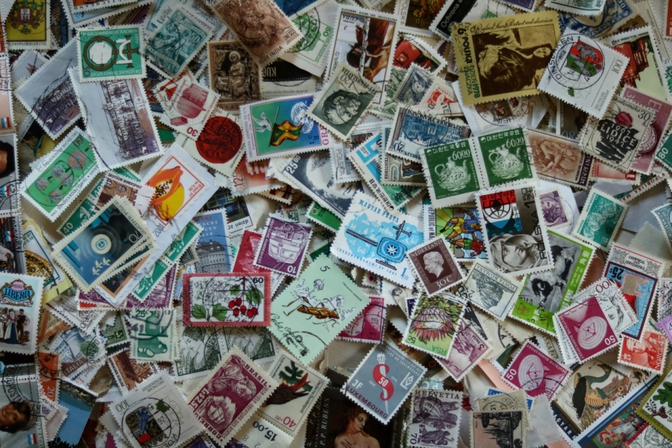 桌面堆放收集纪念邮票散乱摆拍
