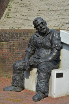 城市街道坐白色椅子老年男性雕塑