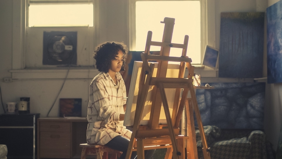 坐在画架前正在绘画的女孩