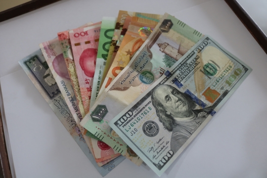 简约书桌上的各国各色百元纸币静物摄影