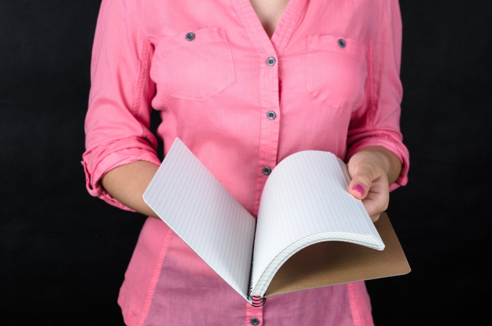 黑色背景粉色衬衫女性打开线圈笔记本