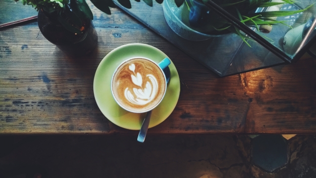 窗边木桌拉花咖啡微距摆拍