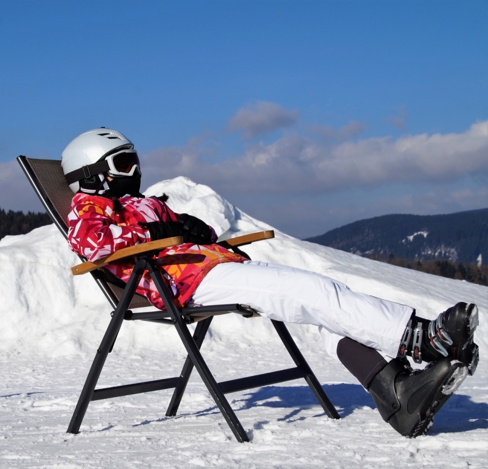 冬天寒冷白色滑雪场坐椅子晒太阳女性