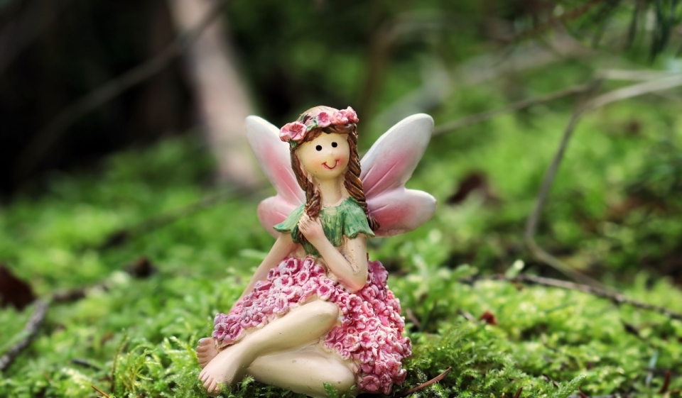 放在林间草地上的花仙子陶瓷娃娃