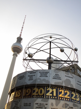 黄昏阳光下高塔旁建筑屋顶的创意雕塑