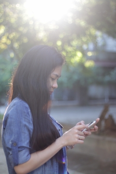 站在阳光下玩手机的美女唯美写真