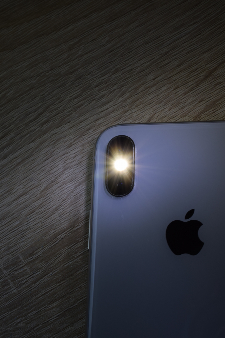黑暗室内桌面闪耀闪光灯灰色iPhone智能手机
