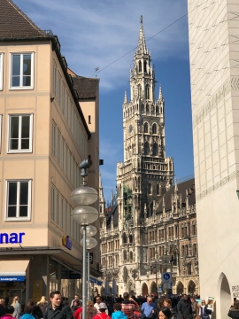 蓝色天空城市街道古老艺术建筑前人群