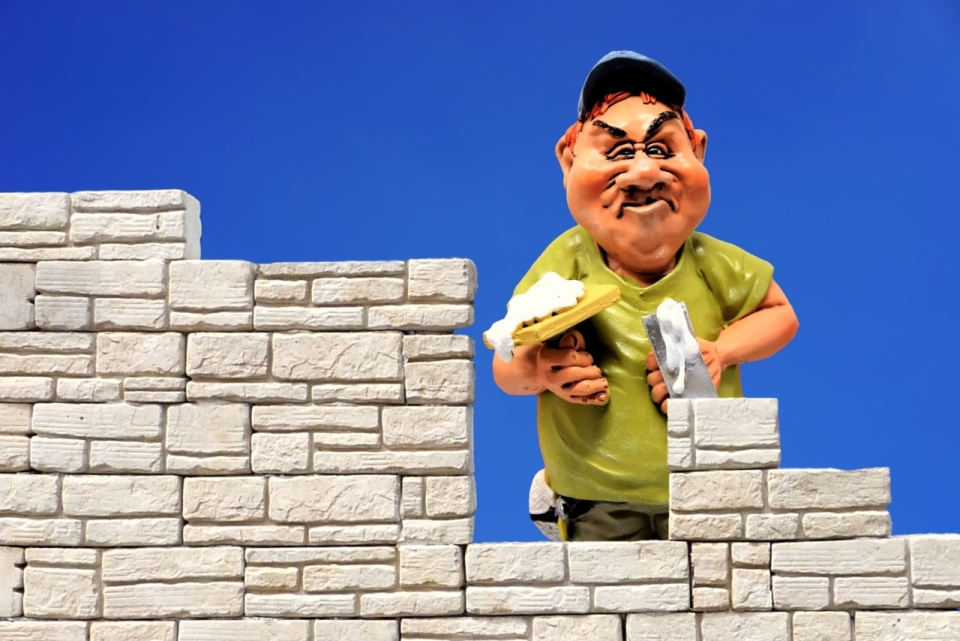 蓝色背景男性砌砖工人彩色模型玩具