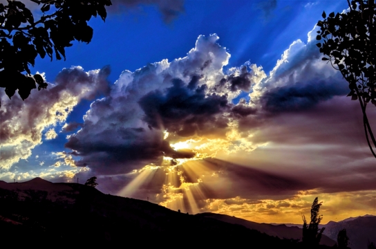 天空云朵遮挡夕阳光晕美景