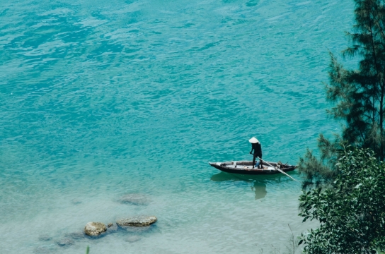 碧海之中划着小船的船夫