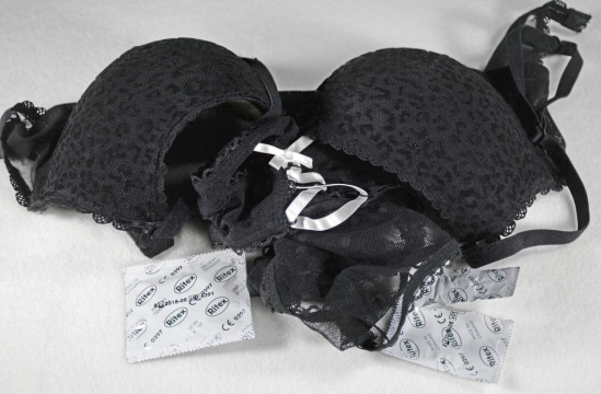 白色背景黑色文胸和安全套特写