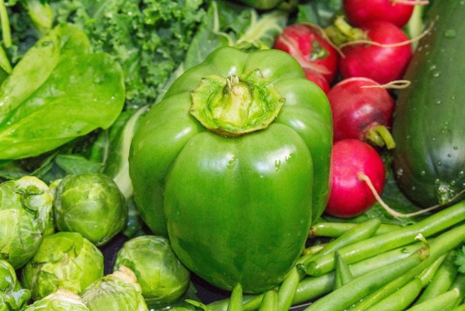 市场摊位上堆积绿色新鲜瓜果蔬菜