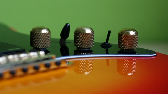 绿色背景电吉他旋钮微距摄影