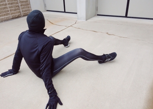 空场地上紧身衣运动装男子戴着帽子坐在地上