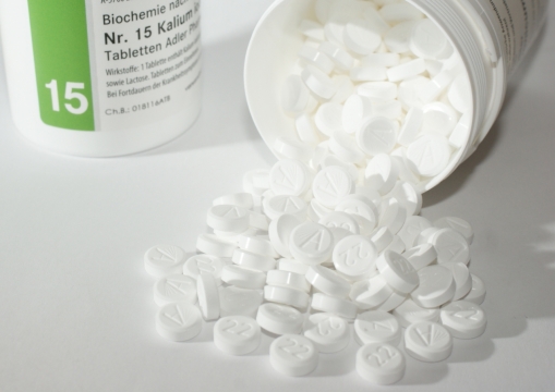 白色桌上倒下洒落的圆形药片