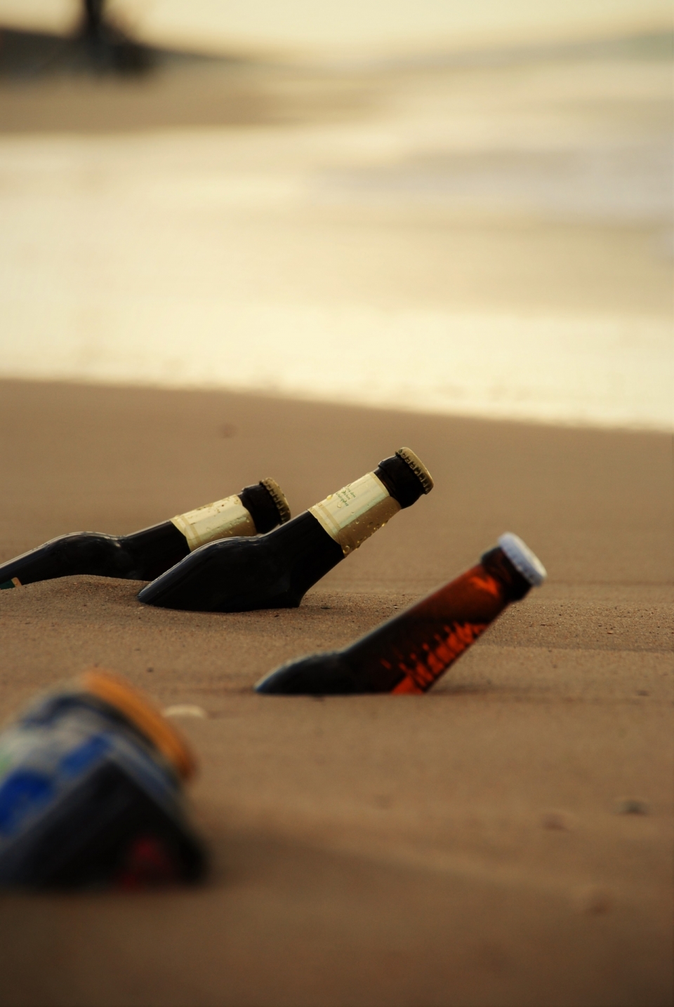 大海边沙滩上埋入一半的啤酒瓶