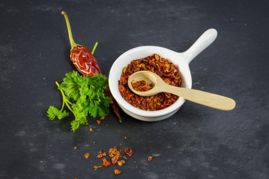 黑色桌面白色容器木制勺子辣椒粉