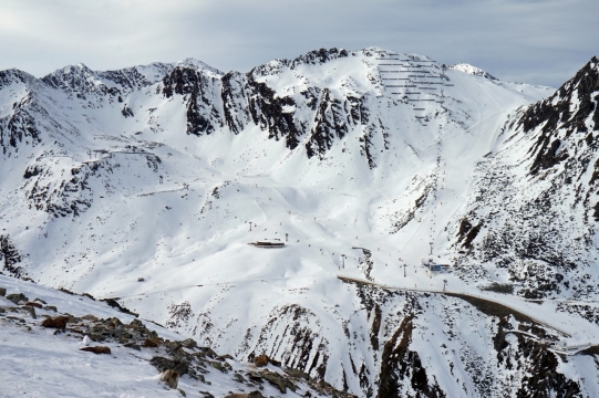 天空下绵延雪山山腰上广阔的滑雪场