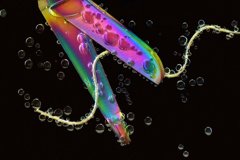 微距拍摄落入水中的彩色瓶子和气泡